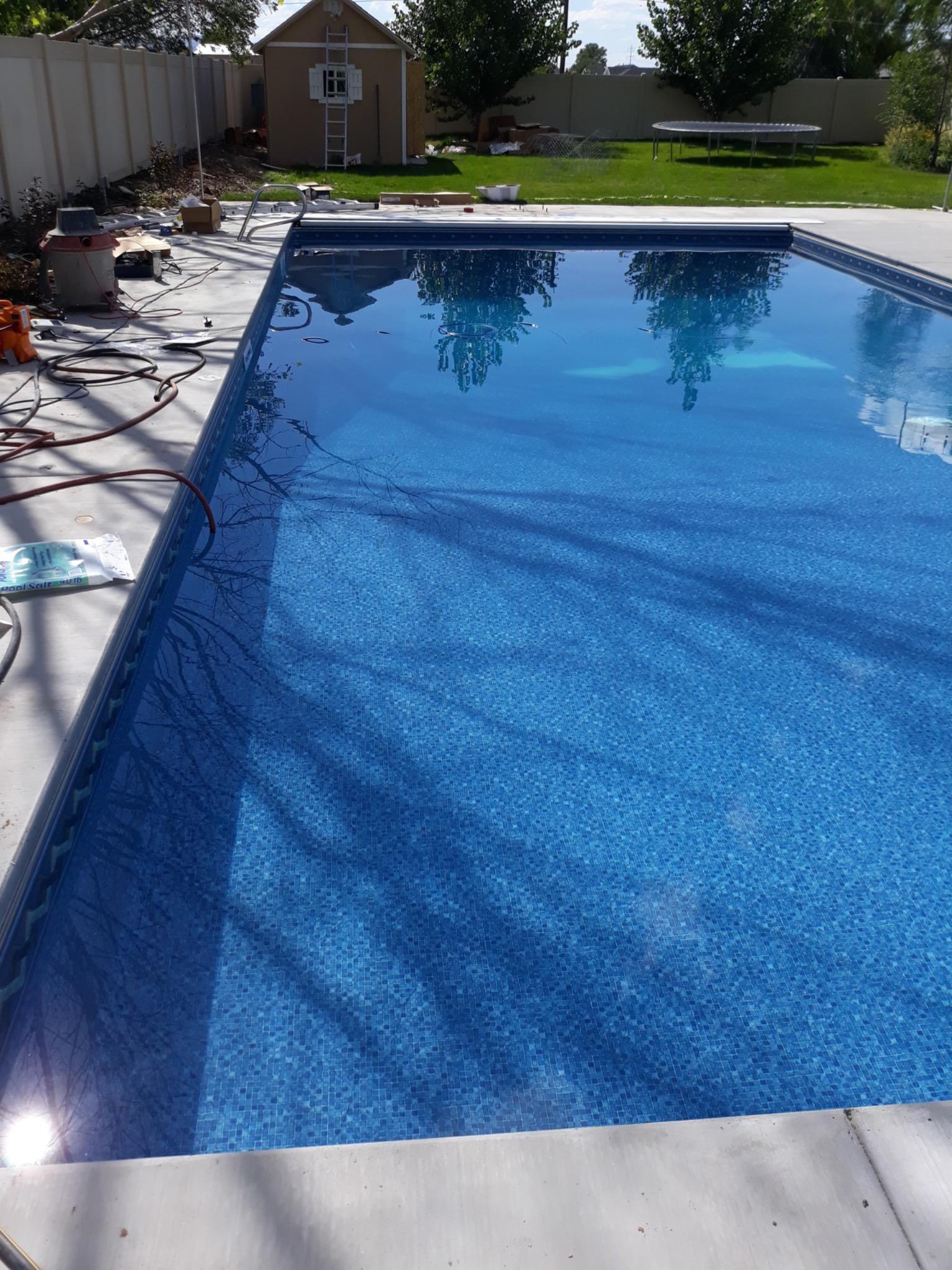 Backyard pool glowing at sunset
